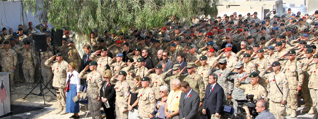Des soldats canadiens saluent les morts sous les yeux des civils. [PHOTO : ADAM DAY]