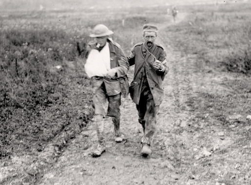 Un Canadien blessé escorte un Allemand capturé à la côte 70. [PHOTO : MUSÉE CANADIEN DE LA GUERRE—19920085-668]