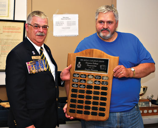 Len Zema du Manitoba acceptant le trophée du jeu des simples. [PHOTO : KAREN TAYLOR-LOPEZ]