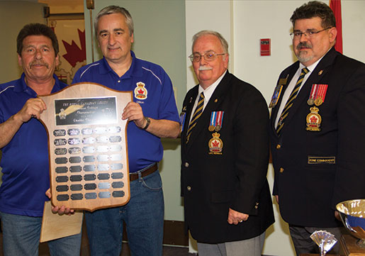 Les gagnants chez les doubles Richard Falle et Barry Dillon reçoivent leur trophée que leur ont remis le président du Comité national des sports, Ed Pigeau, et le commander de zone, Len Burnham. [PHOTO : TOM MacGREGOR]