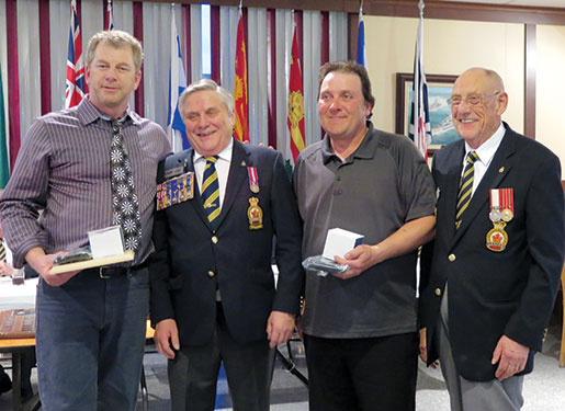 Le duo champion Sheldon Fudge (à g.) et Kevin Boyland (2e à p. de la d.) de la filiale New Ross (N.-É.) sont félicités par le représentant du Comité national des sports Angus Standfield (2e à p. de  la g.) et le président du comité local des préparatifs, Len Marks. [PHOTO : SHARON ADAMS]