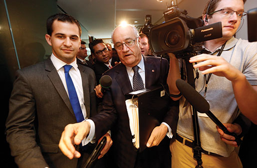 Le ministre des Anciens combattants, Julian Fantino (au c.) passe devant les journalistes après avoir témoigné par-devant le Comité permanent des anciens combattants de la Chambre des communes en mai. [PHOTO : REUTERS/Chris Wattie]