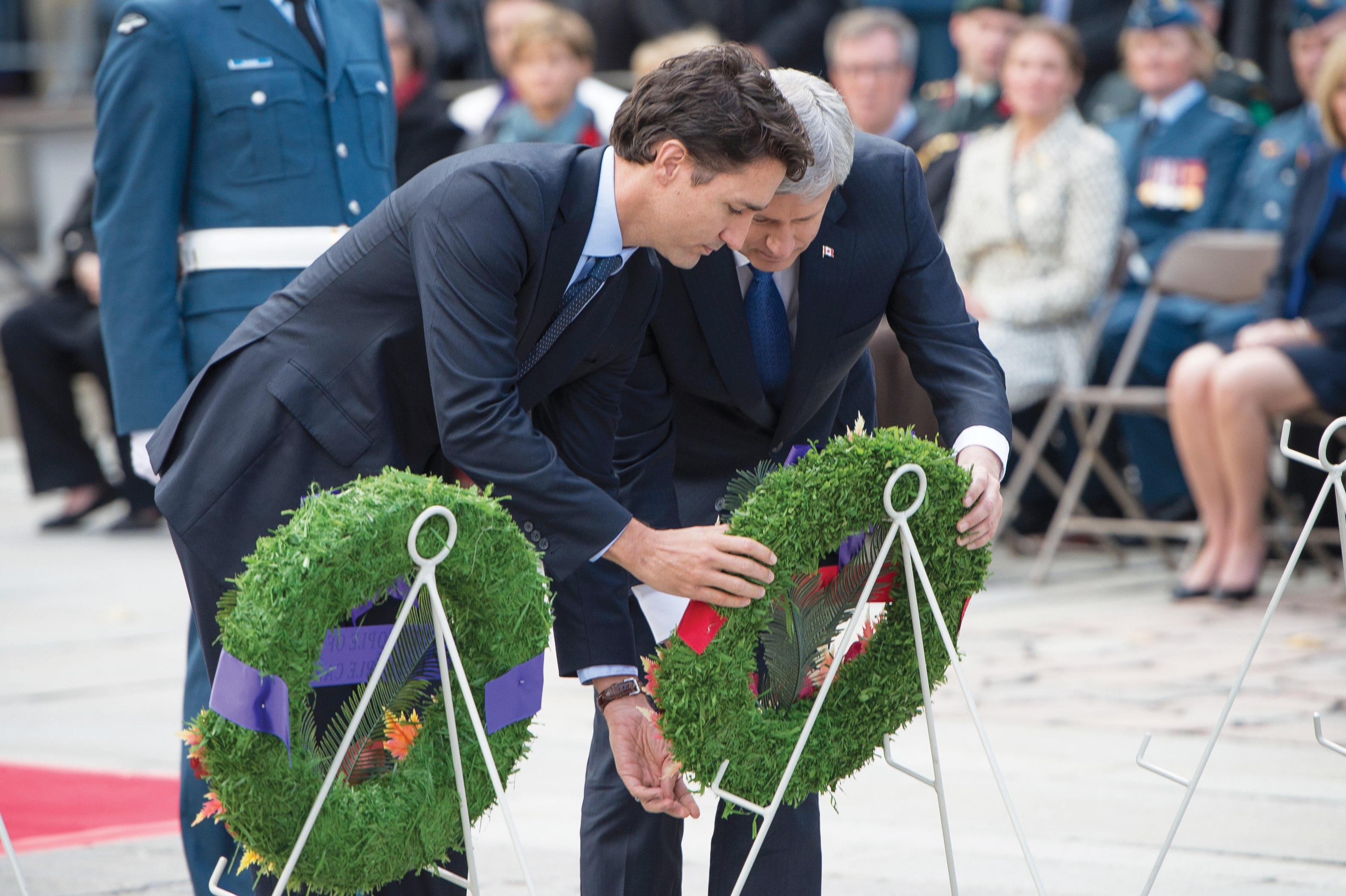 Le premier ministre désigné Justin Trudeau (en h., à g.) et le premier ministre Stephen Harper déposent une couronne.